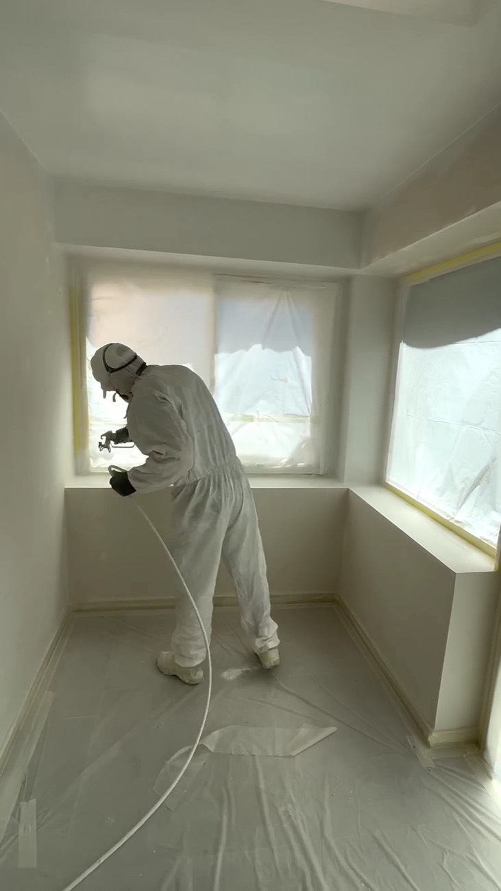 Application de peinture au pistolet airless, en combinaison de protection